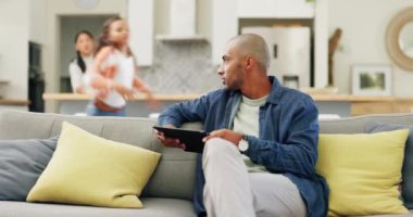 Baba, çocuklarıyla birlikte evdeki oturma odasındaki kanepede bir tablet üzerinde video izliyor. Sosyal medyada ya da internette dijital teknolojide kız çocuklarla kaynaşma, aşk ve genç baba.