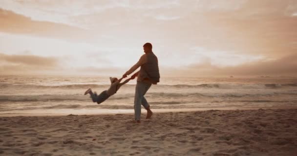 ビーチ 父親は朝に砂の上に結びついている間に娘を紡いでいます 楽しみ そして自然の中で屋外で遊んでいる父親 — ストック動画