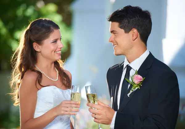 Happy couple, wedding and champagne in celebration for marriage, love or commitment at outdoor ceremony. Married man and woman smile with glass of alcohol for toast, date or cheers on honeymoon.