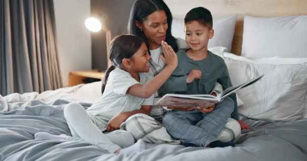 孩子们和书本一起在床上看书 一起笑 一起学习语言 高五或回家 有儿子的母亲和女儿 讲故事时间或家庭住房中的教育目标 — 图库视频影像