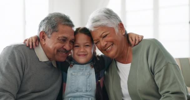 面对孩子 快乐的祖父母和抱在沙发上的客厅里 关怀和美好的时光在一起 女孩的画像抱着奶奶 爷爷和家人 带着微笑在家里放松 — 图库视频影像