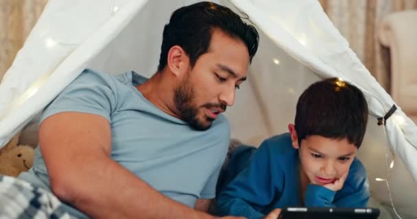 子供がオンラインで映画 ビデオ またはショーを見ているテントの中で結合 タブレットや父親 笑顔と自宅で毛布の砦でデジタル技術に男の子の子供とソーシャルメディア上の若いお父さんネットワーキング — ストック動画