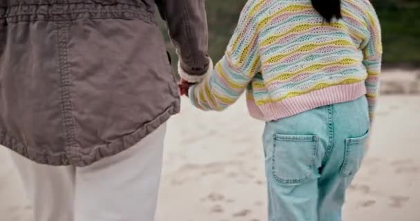 海滩和一个家长牵着一个孩子的手在海边的沙滩上散步 孩子和暑假或暑假的人在一起旅行和亲密接触 — 图库视频影像