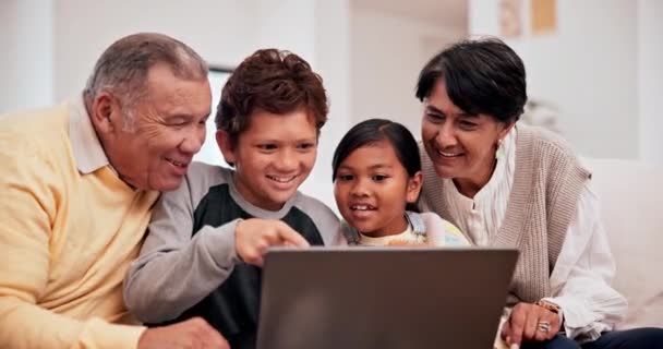 祖父母和孩子们一起坐在笔记本电脑上 或者一起在沙发上的客厅里开心地参观 老年男女带着孩子和上网进行电子学习或游戏的肖像 — 图库视频影像