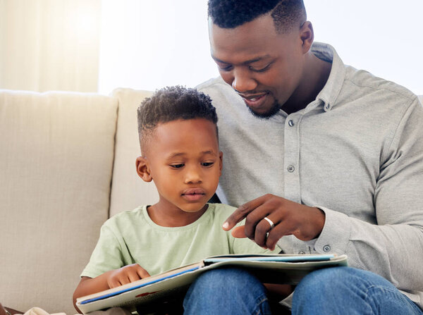 African, father and child in home reading book on sofa with development of education, learning and knowledge. Happy dad, teaching and show kid a story in books and relax in living room on couch.