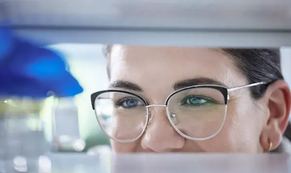 Science, search and the eyes of a woman in a lab for research, innovation or medical storage. Healthcare, medical and pharmaceuticals with a happy scientist in a laboratory for cure development.