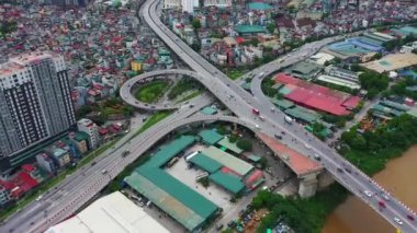 Şehrin arka planındaki sokak, ulaşım ve binaların insansız hava aracı, yol altyapısı ve trafik veya arabalar Vietnam 'da seyahat ediyor. Kentsel mimaride Asya nüfusu, karayolu köprüsü ve nehrin havadan görünüşü.