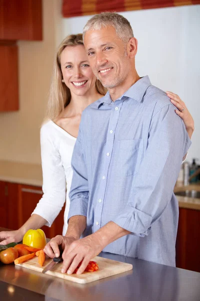 Kitchen, cooking and portrait of couple with vegetables for healthy dinner, lunch and ingredients. Retirement, marriage and mature man and woman cutting food for bonding, help and meal prep at home.
