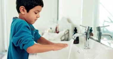 Genç çocuk evde el yıkama, hijyen ve sağlıkla sürdürülebilirlik, su ve rutin yöntemlerle. Banyoda erkek çocuk, lavaboda sabun ve köpükle temizlik, el yıkama ve dezenfekte ile sağlıklı..