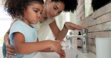 Anne, çocuk ve diş fırçalama banyoda hijyen için su, sabah rutini ve evde sağlıklı öğrenme. Anne, kız çocuk ve diş temizliği taze nefes bakımı için ıslak diş fırçasına..