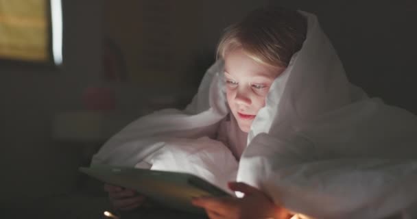 オンラインゲーム 電子ブックストーリーや学習アプリのための夜の寝室で毛布 女の子やタブレット 若い子供は暗闇の中でデジタル技術 接続またはストリーミング漫画エンターテイメントにリラックス — ストック動画