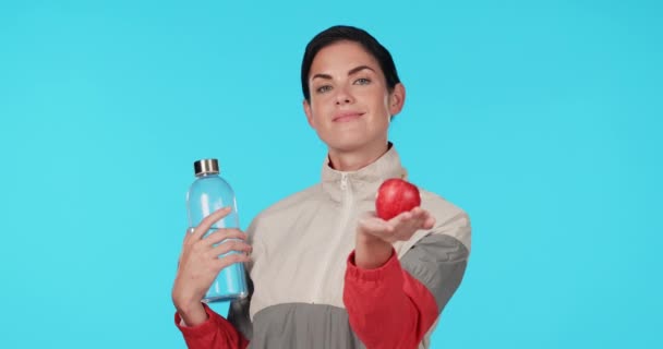 面部和女性 有一个蓝色背景的苹果 有营养和饮食用水 在工作室的背景下 带着水果和酒瓶进行健身排毒的女孩的微笑 健康和肖像 — 图库视频影像