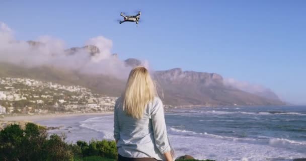 海滩上 飞行员和女人在海上驾驶无人驾驶飞机 在大自然中穿梭 在海上控制无人驾驶航空器 在探险 度假或拍电影时控制机器人和四足动物的技术 后背和人员 — 图库视频影像
