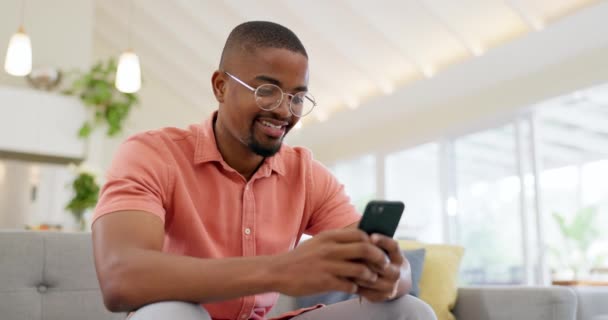 Gelukkig Typend Een Zwarte Man Met Een Telefoon Bank Voor — Stockvideo