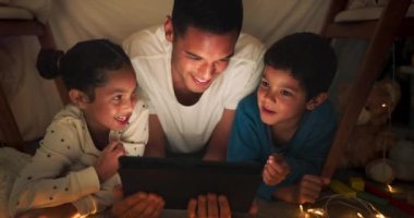 Komedi, tablet ve çocuklu bir baba bir çadırda internet videosu, şov ya da film izliyorlar. Karanlık, dijital ve ebeveyn ya da baba rahat olun. Çocuklar akşamları komik uygulamalar izliyor..