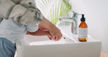Anne, banyoda hijyen için musluk takan çocukların ellerini yıka ve evde yakın çekimde öğren. Su, temizlik ve mikroplar için el yıkama ile öğretmek ya da mikropları, bakterileri ya da virüsü önlemektir.