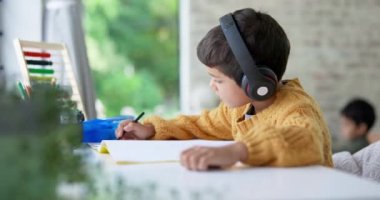 Erkek çocuk, ev ödevi ve kulaklıkla yazı, müzik ve öğrenme, çizim ve eğitime odaklan. Genç erkek çocuk, aile evinde notlar ve sesli yayın, radyo ya da dinleme ile ders çalışıyor..