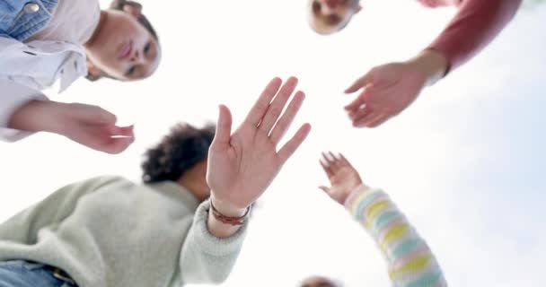 手拉手 团队团结在下面 在天空的背景下进行合作或庆祝 为了团队合作的动机 支持或协调 父母和孩子携手合作 — 图库视频影像