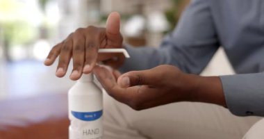 İnsan, el ve dezenfekte için dezenfektan, hijyen ve evde sağlık, güvenlik ve koruma için temizlik. Erkek bireyin sıvı şişeyle yakınlaştırılması ve bakteri veya mikrop temizleme için ellerinin birbirine sürtünmesi..