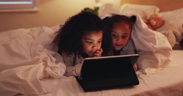 夜の寝室の女の子 タブレットや子供たち ボンディングやストリーミング映画 ビデオや映画 テクノロジー ベッドの上の子供や姉妹 ゲーム スクロールアプリのためのインターネットとソーシャルメディアと毛布でリラックス — ストック動画