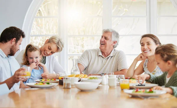 Dinner, children and happy in big family home with eating, talk and laugh with mom, dad and grandparents. Men, women and kid for food, lunch or brunch for memory, conversation or smile in dining room.