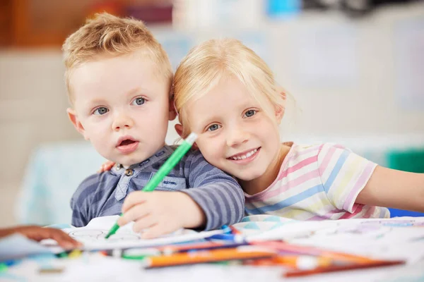 Face, kid or friend with drawing in classroom for learning, education and development of motor skills. Little girl, boy or student with smile for art project, homework or assessment in kindergarten.