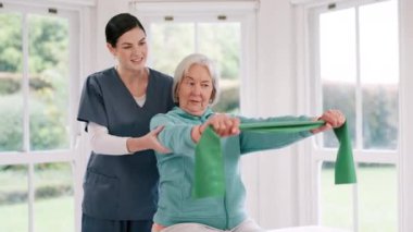 Kadın, doktor ve fizyoterapide direnç bandı olan kıdemli bir hasta. Yaşlılıktan sonra spor yapıyor. Evde esneme, egzersiz ya da terapide olgun kadınlara yardım eden terapist ya da hemşire..