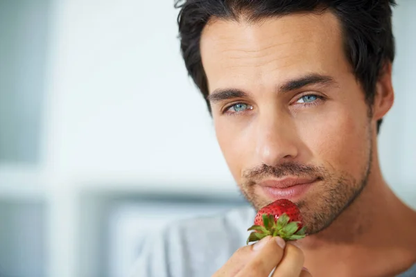 Man, portrait and strawberry eating for breakfast meal or wellness health, diet nutrition or morning snack. Male person, face and fruit berries for vitamin fibre food for weight loss, vegan or detox.