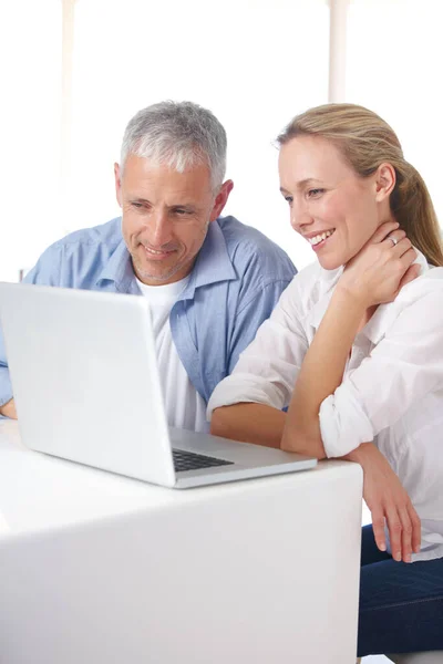 Mature couple, laptop and video call with smile, conversation and living room couch. Social media, technology and communication with family, man and woman with connection, streaming and happy.