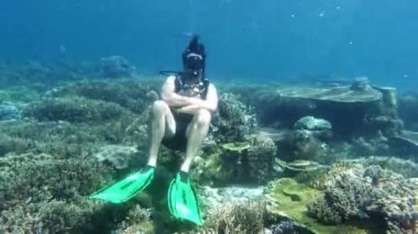 Scuba dalgıcı, macera, mercan resifi ve derin denizde iyi bir emoji için su altında ve okyanusun altında oturuyor. Endonezya 'da balık, tatil veya özgürlük okulu, deniz hayvanları veya ekosistem ve Raja Ampat' a seyahat.