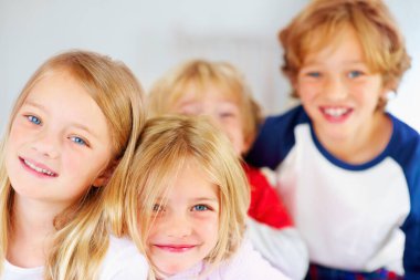 Portrait, smile or happy children with brother and sister siblings on a bed in their home together. Family, love or bonding with young boy and girl kids in the bedroom of an apartment on the weekend. clipart