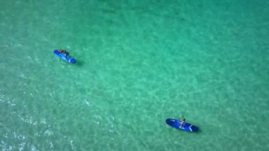 Okyanus, macera ve mavi suyu, özgürlüğü ve tropikal yaz tatili olan drone 'lardan gelen çift kürekleri. Eğlence, spor ve rahatlama, erkek ve kadın yukarıdan deniz seyahati için kürek çekiyor.
