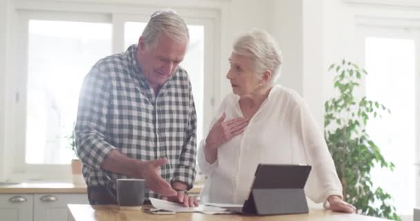シニアカップル ドキュメント 財務書類 住宅ローンのタブレットでの計画 キッチンでの質問 高齢者は 財政費や請求の間違いのためにストレスを抱えています — ストック動画