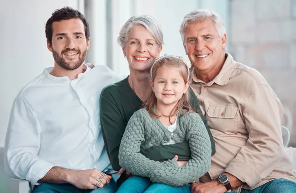Grandparents, girl and father in portrait on sofa with hug, care or bonding with love in family home lounge. Elderly people, kid and dad with smile, relax and together on living room couch in house.