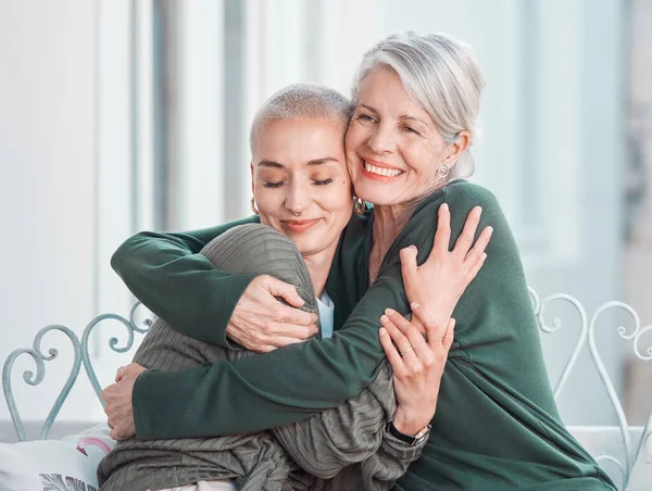 Happy, hugging and senior mother with woman in the living room for bonding, love and care at home. Smile, sweet and elderly female person in retirement embracing adult daughter at house in Australia