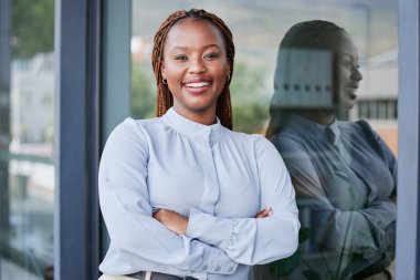 Mutlu, çapraz kollar ve ofiste pozitif, iyi ve kendine güvenen profesyonel siyahi bir kadın. Gülümse, zeki ve iş yerinde hukuk kariyeri olan genç Afrikalı kadın avukatın portresi.