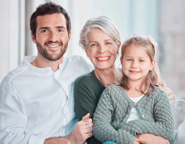 Father, grandmother and girl with smile in portrait, hug and care with love, bonding and relax on chair. Dad, elderly woman and child with embrace, happy together and living room in family house.