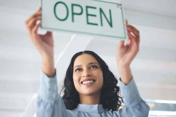 Woman, open sign and window store for company hours as professional owner, entrepreneur for customer notice. Female person, smile and holiday information for sales poster, service news for welcome.