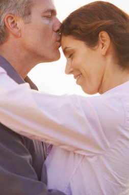 Çiftler, emeklilikte sevgi, saygı ya da mutlulukla öpüşün ve sarılın. Olgun, erkek ve kadın tatilde gün batımında dışarıda kucaklaşır ya da evlilikte sevgi ya da minnettarlık gösterirler..