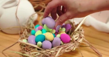 Paskalya, el ve dekorasyon, tatil için yumurta, şenlik ya da kutlama için eve yakın çekim. Kadın, parmak ve sepetteki yer, bahar, umut ve inancın sembolü için hazırlık veya gelenek.