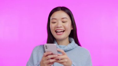 Asyalı kadın, telefon ve mesajlaşma stüdyoda kahkahalarla sosyal ağ uygulaması, mim ve pembe arka plan ile komik. Japon öğrenci, akıllı telefon ve gülümseme ile sohbet, komik yazı ve blog ile daktilo.