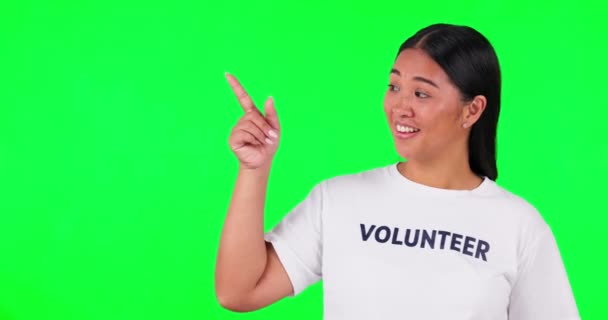 慈善または情報のためのスペースを指している緑の画面 ボランティアと女性 スタジオでの非営利プレゼンテーション Ngoチェックリストや寄付のためのリストとTシャツを持つ幸せなアジア人 — ストック動画