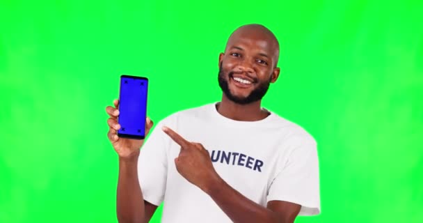 黒人男性 電話やモックアップでポイント 緑の画面とボランティア スタジオの背景にアプリとコミュニティサービス ウェブサイトの登録 慈善事業の登録 男性のヘルプとマーカーの追跡 — ストック動画