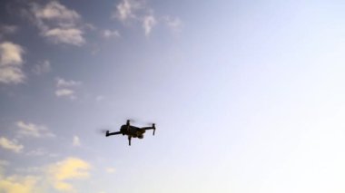 İnsansız hava aracı, gökyüzü ve dışarıdaki bulutlardaki kuadkopter uçuşu, casus ya da video izleme elektroniği. UAV, hava ve gelecekteki robot teknolojisinde uçan makine, uçak yeniliği veya helikopter fotoğrafçılık için havada asılı duruyor.