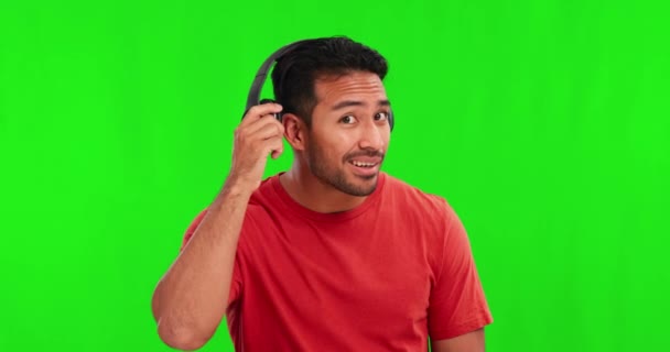 音楽やオーディオのためのヘッドフォンを持つアジアの男の緑の画面 リスニングと顔 スタジオの背景に隔離された人や男性Djストリーミングの幸せ 応答と肖像画 — ストック動画