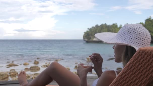 휴가를위한 라운지 의자에 해변이나 바다에 칵테일과 휴식을위한 알코올이있는 바다에 관광객 — 비디오