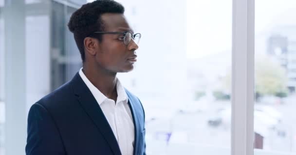 企业和一个严肃的黑人男人在他的办公室的窗口为专业工作或职业 一个有自信的年轻员工在工作场所穿西装的肖像 生意和眼镜 — 图库视频影像