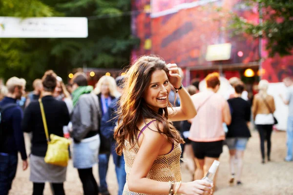 Music, festival and portrait of woman at a concert, field with crowd and audience or excited fan at event. Happy, girl and walking to stage or dancing with drink at party with alcohol and celebration.