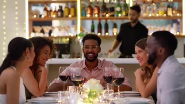 在餐馆里 朋友们在一起喝酒 谈笑风生 同时聊天 结伴和庆祝 男人和女人在奢华晚餐约会时都会带着微笑放松 — 图库视频影像
