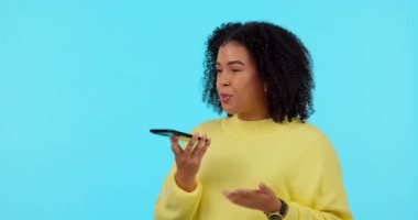 Konuşma, iletişim kurma ve stüdyoda mavi bir arkaplanda izole edilmiş yeşil ekrandaki bir kadın. Konuşma, modelleme ve sesli mesaj ve iletişim için cep telefonu olan bir kız..